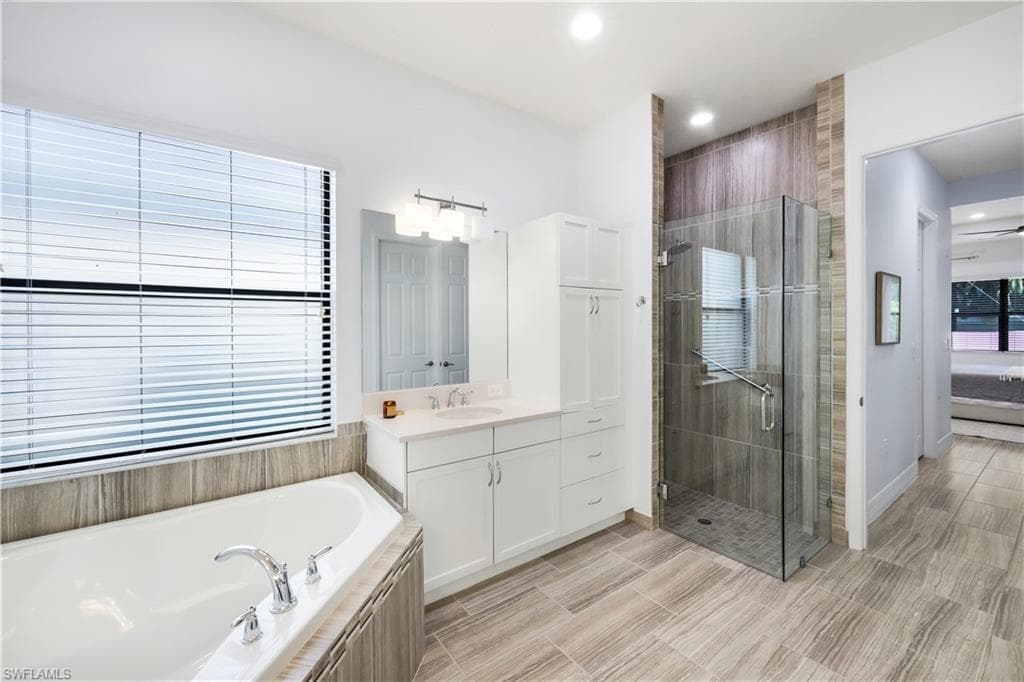 Primary bathroom with glass enclosed shower, dual sinks and tub.