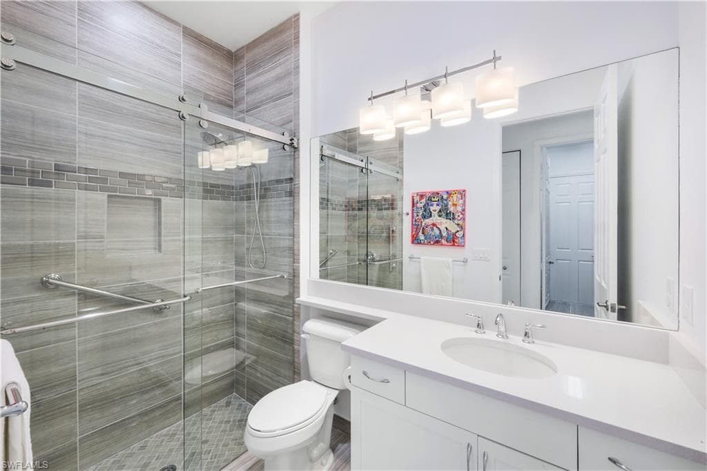 Guest bathroom 2 with barn door style glass doors for shower/tub, tiled shower and vanity.