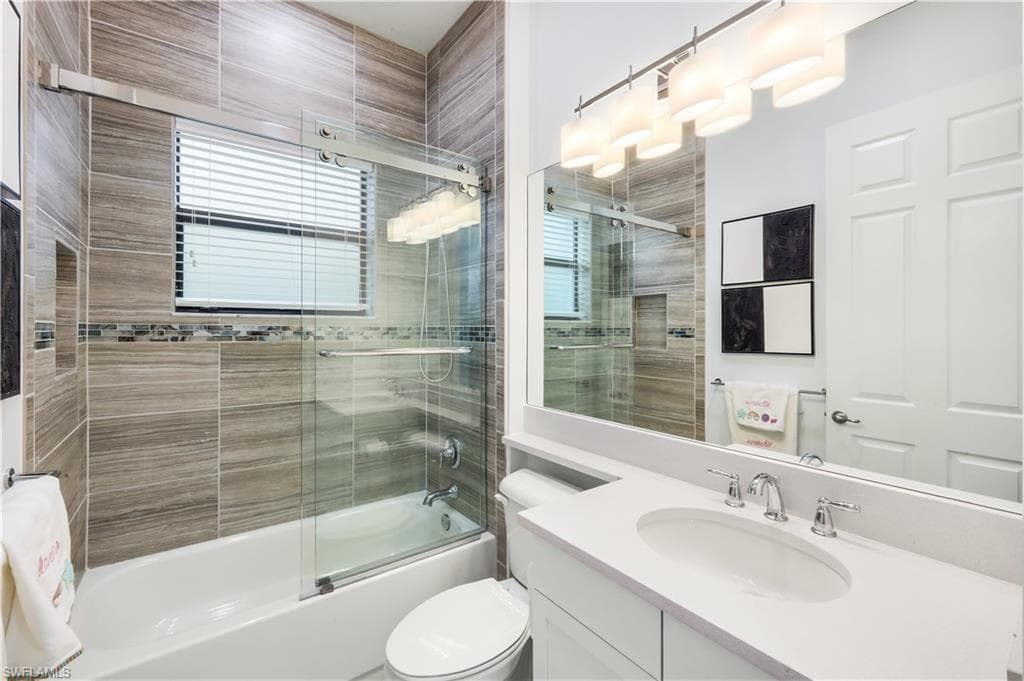 Guest bathroom 1 with barn door style shower/tub, tiled shower and vanity.