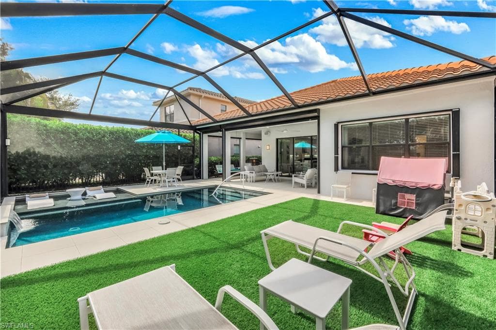 Lounge/play area with artificial turf, sundeck, pool, covered seating area, built-in kitchen, electric hurricane screens and enclosed lanai.
