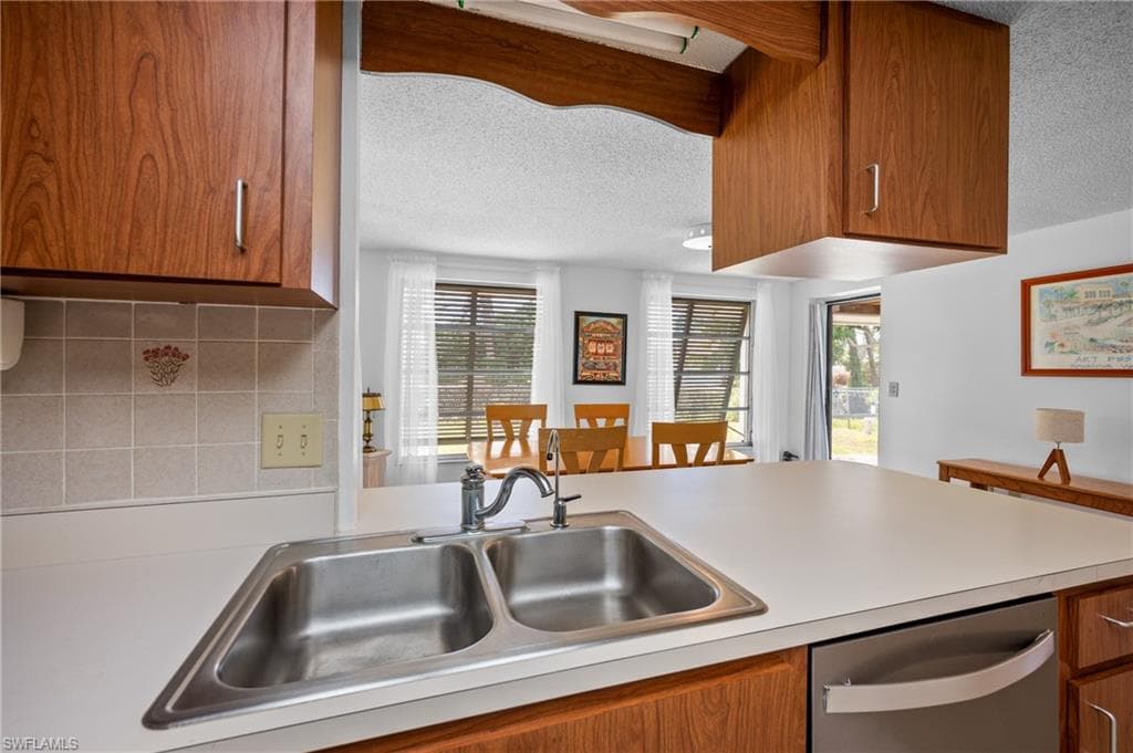 Kitchen featuring wood-finish cabinetry and a double basin stainless steel sink