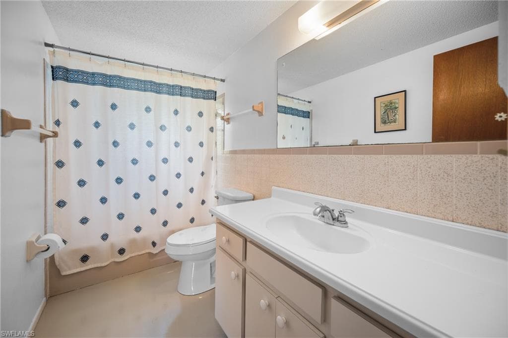 Bathroom featuring a single vanity with an integrated sink, polished chrome faucet, and a large wall-mounted mirror