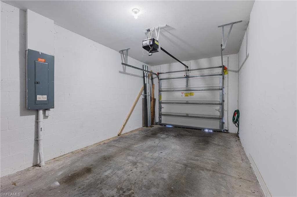 Garage featuring electric panel and a garage door opener