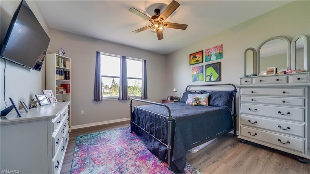Bedroom with ceiling fan and dark hardwood / wood-style floors