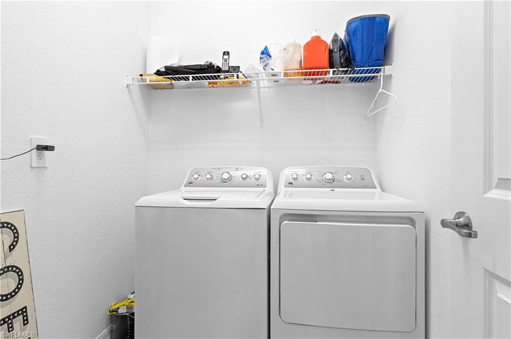 Laundry area with separate washer and dryer and a textured wall