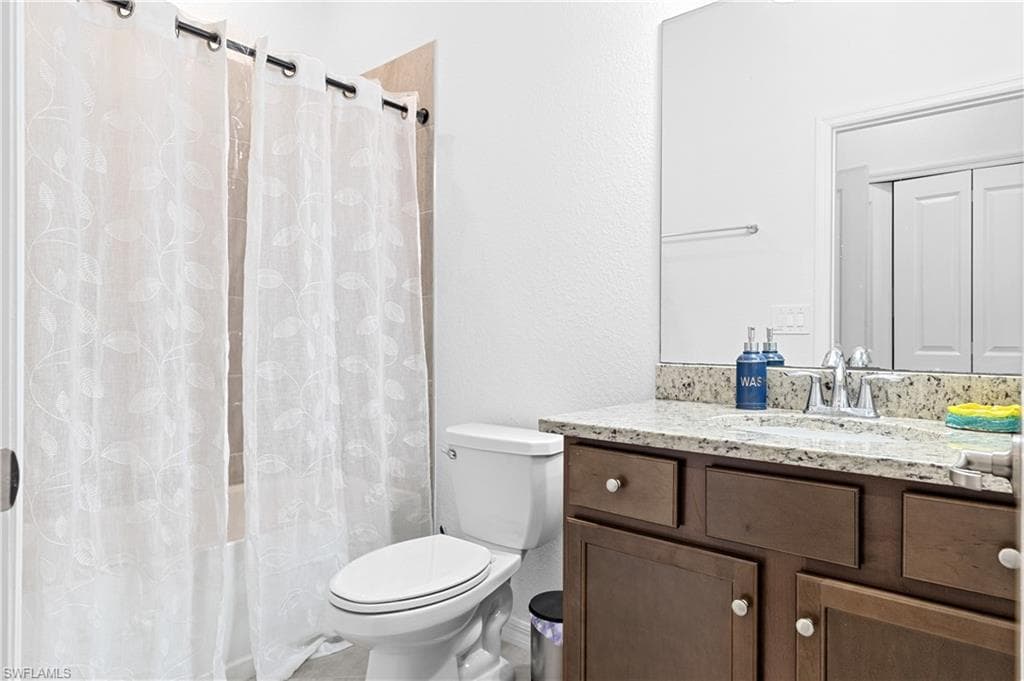 Guest on-suite Bathroom 1 with vanity and shower / bath combo with shower curtain