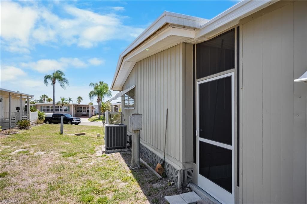 Exterior featuring vertical siding and a screened entry door