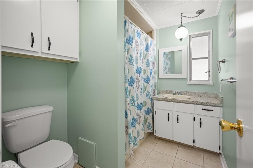 Bathroom featuring a white vanity with a light-colored countertop, an undermount sink, and a framed mirror
