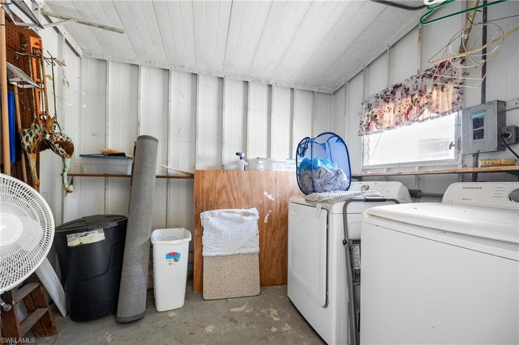 Dedicated utility space featuring white paneled walls, a single window, and a concrete floor