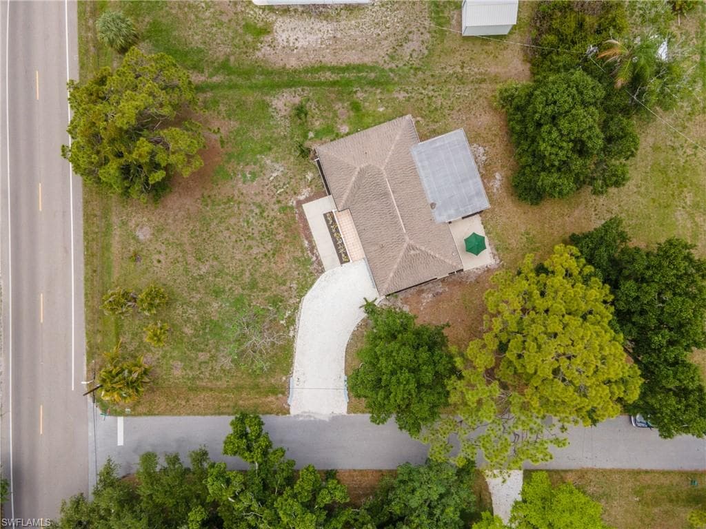 Aerial perspective showcasing a single-story residence with a pitched roof and a screened lanai