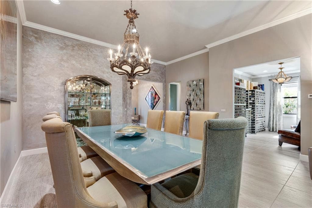 Dining room with crown molding, baseboards, and an inviting chandelier