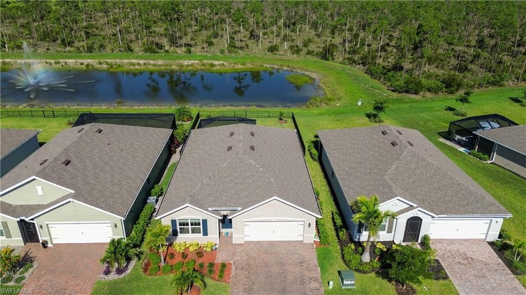 Aerial perspective showcasing a light-colored single-story residence with a gray shingle roof, paved driveway, and landscaping