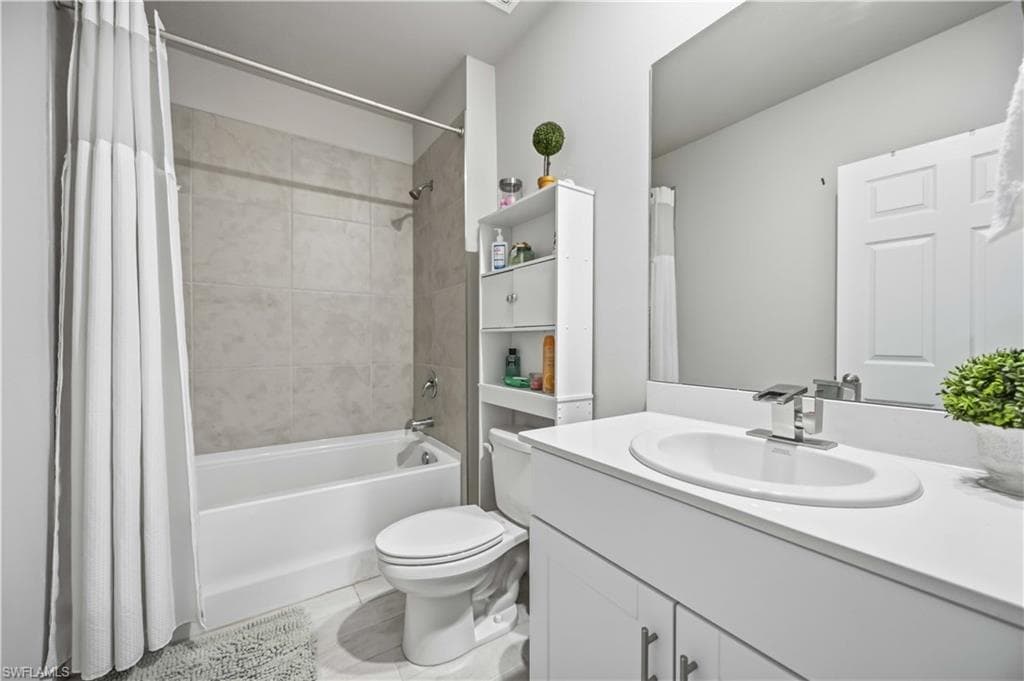 Contemporary bathroom featuring a white vanity with an undermount sink and chrome faucet, a full-width mirror, a white toilet, and a bathtub with light-colored tile surround
