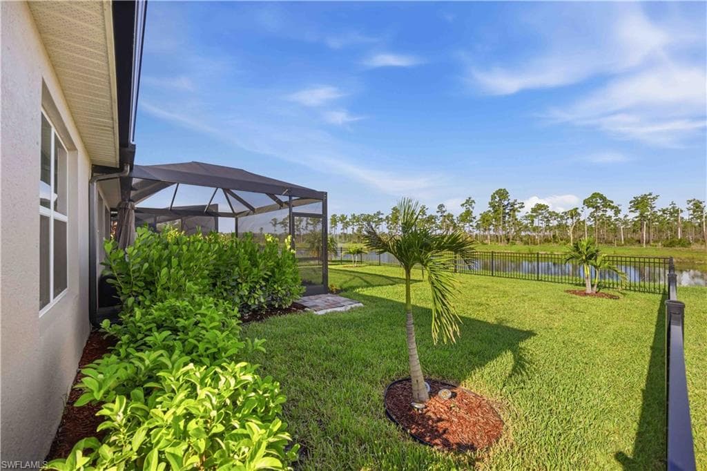 Screened patio enclosure with a dark finish, verdant landscaping, and a manicured lawn