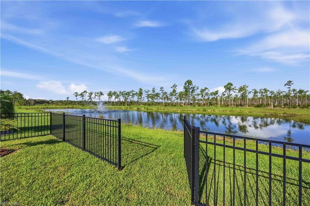 Fenced grassy yard with pond frontage