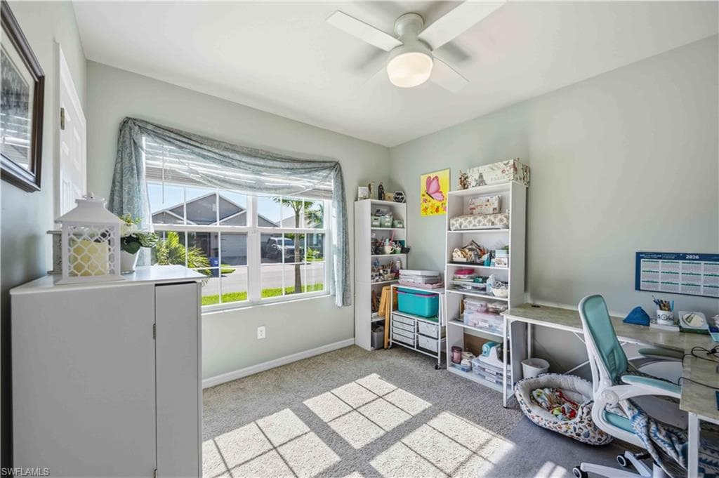 Carpeted room with a large window, a ceiling fan with integrated lighting, and light gray wall paint
