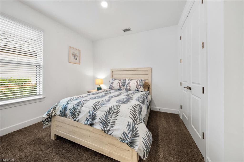Bedroom featuring a window with blinds, recessed lighting, white walls, and brown carpet flooring