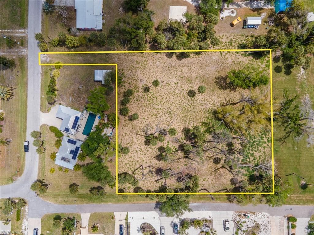 Expansive undeveloped land parcel featuring natural ground cover and scattered mature trees