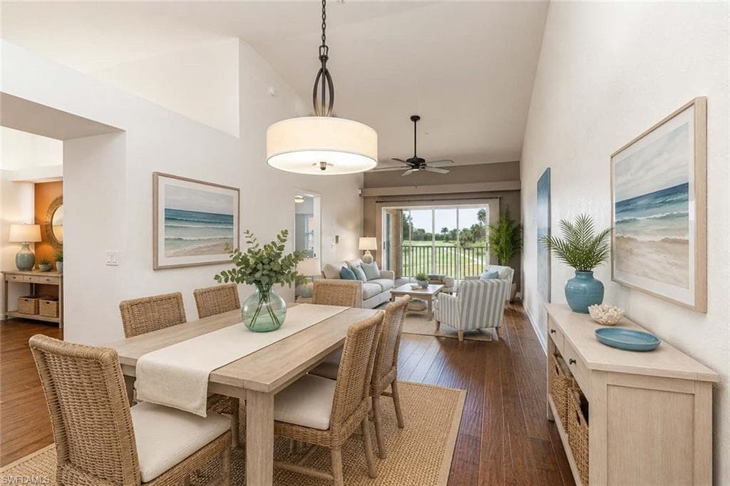 Virtually Staged Open-concept Dining/Living area with vaulted ceilings, wood flooring, a contemporary drum pendant light fixture, and sliding glass doors opening to outdoor space