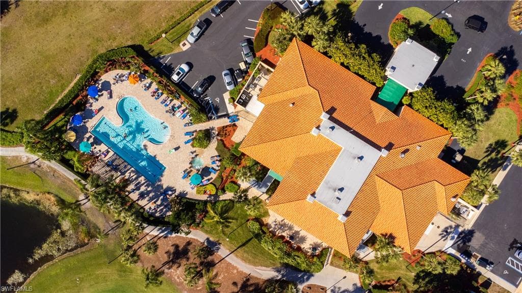Resort-style pool area with integrated lap lanes, extensive paver decking, and various seating arrangements