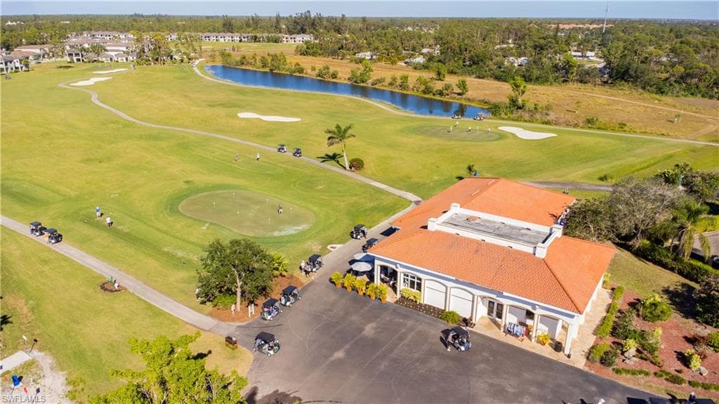 Expansive golf course setting featuring manicured greens and a water feature