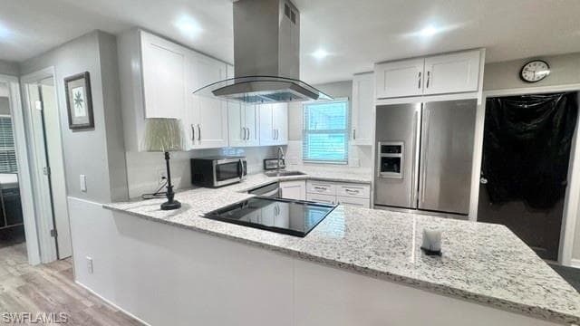 Modern kitchen featuring white shaker cabinetry, stainless steel appliances, a built-in cooktop, and speckled light-tone countertops