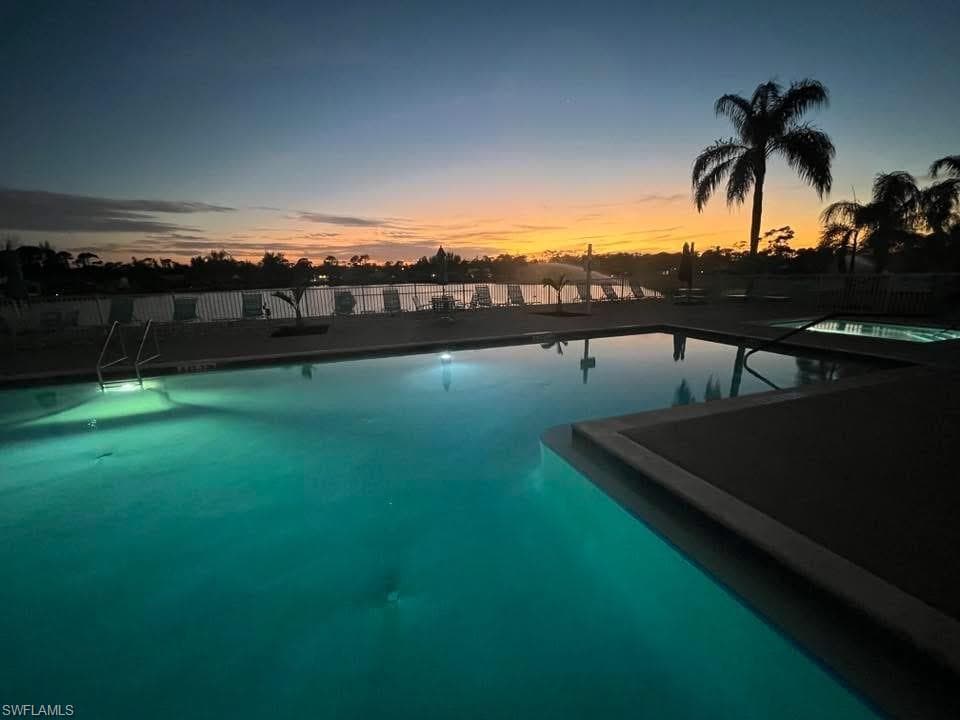 Illuminated swimming pool with integrated spa and surrounding deck