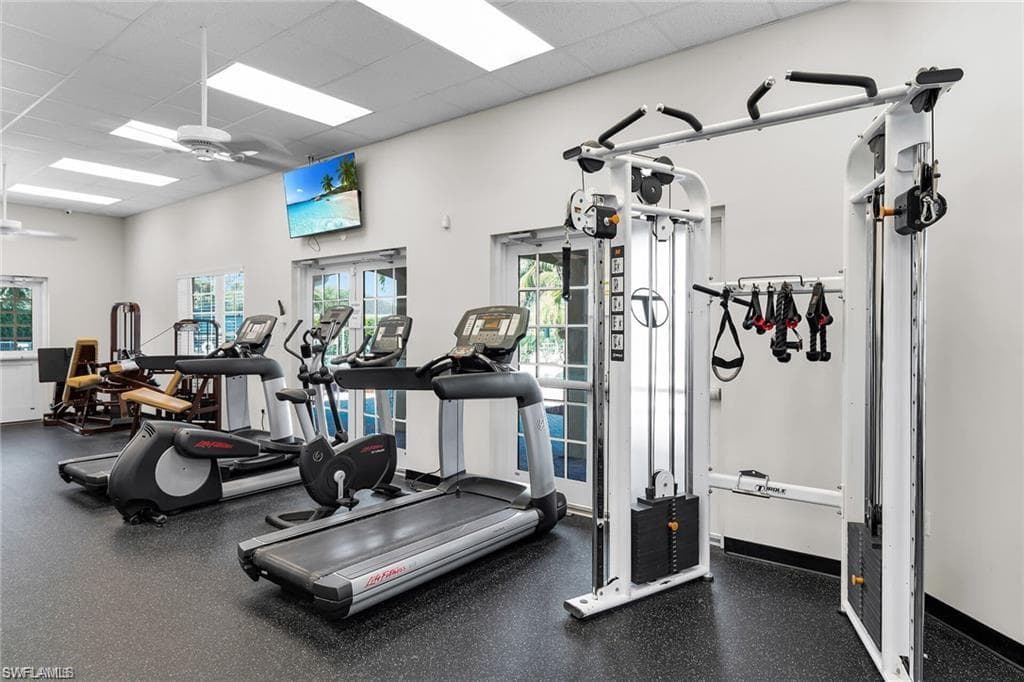 Dedicated fitness room featuring cardio equipment, strength training machines, and a multi-station cable system
