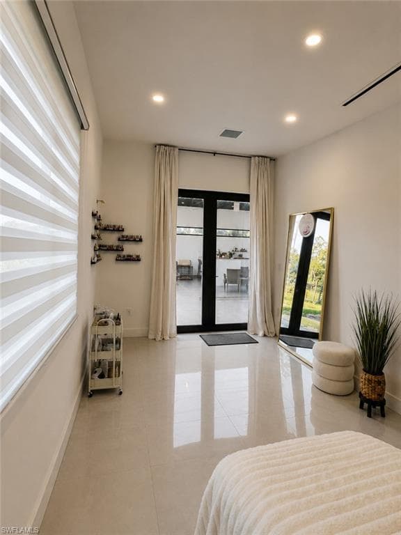 Room featuring large format tile flooring, recessed ceiling lighting, and a wide window with modern blinds