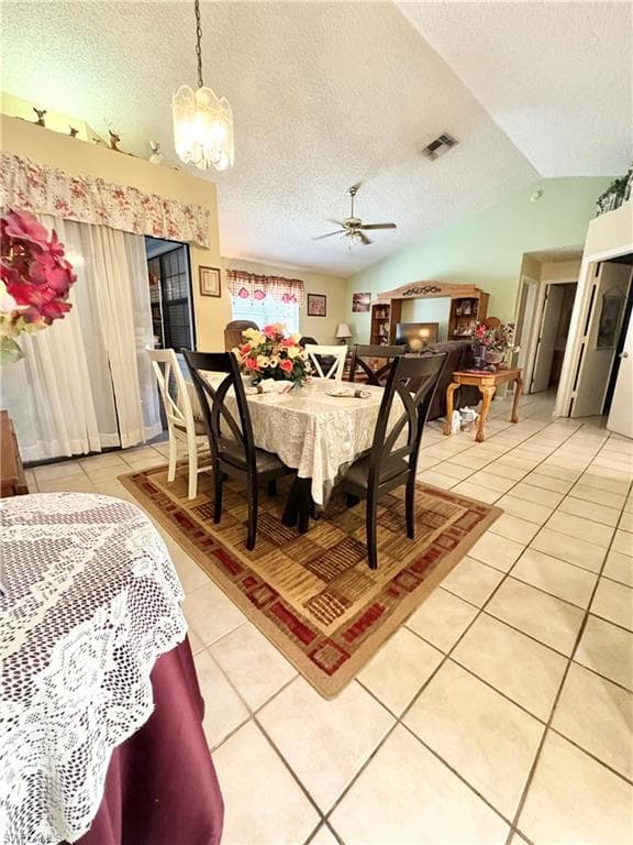 Open-concept living space with tile flooring throughout, a vaulted ceiling, and a ceiling fan