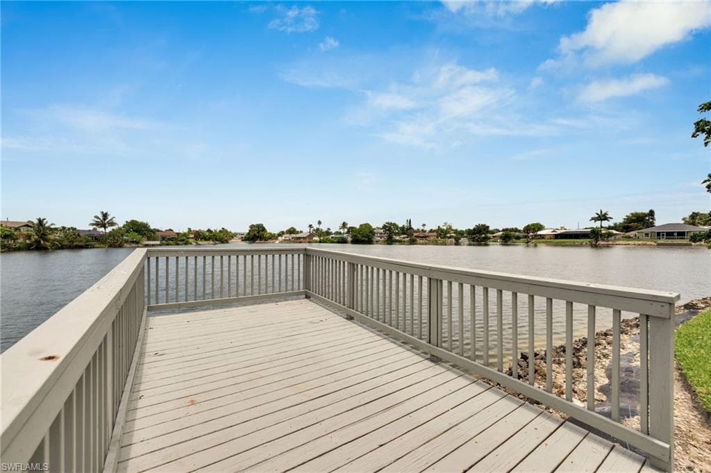 Waterfront deck featuring a light-toned wood-finish surface and matching railings