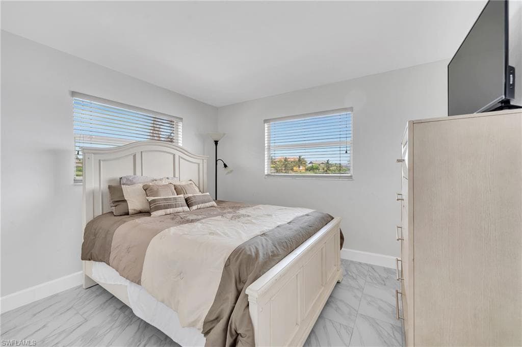 Neutral wall finishes and light-toned flooring complement the dual windows, each fitted with horizontal blinds