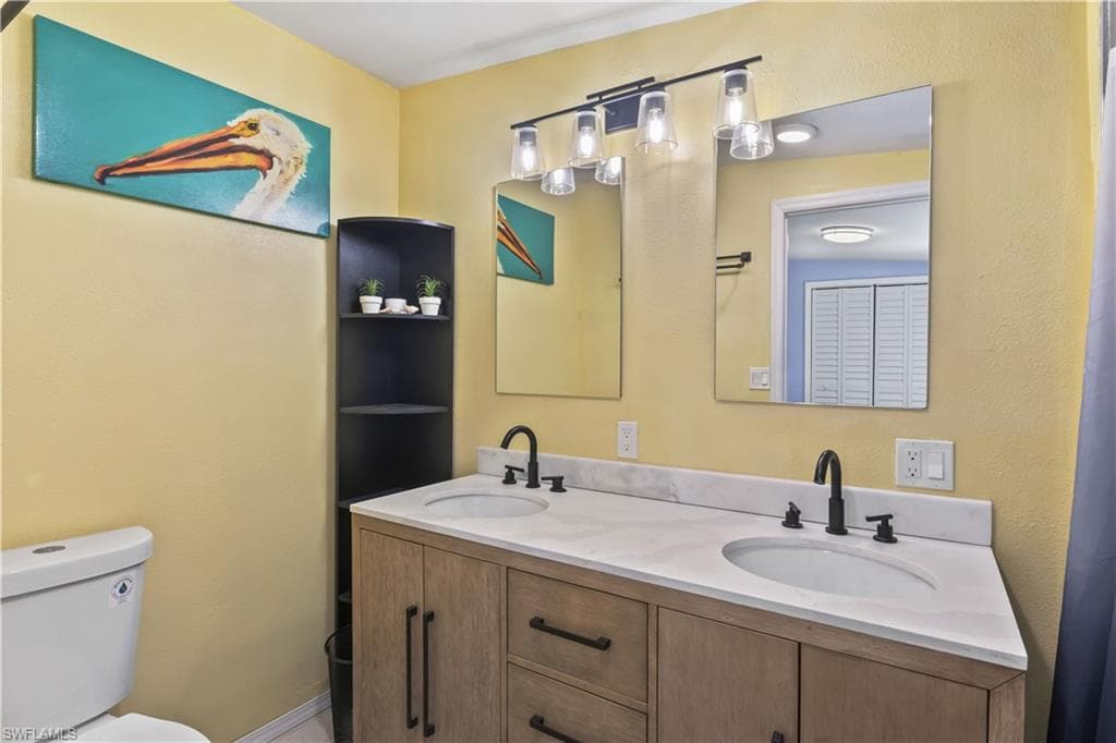 Primary bathroom features a stylish double-sink vanity with modern finishes, while both bedrooms offer comfortable accommodations for owners & guests alike