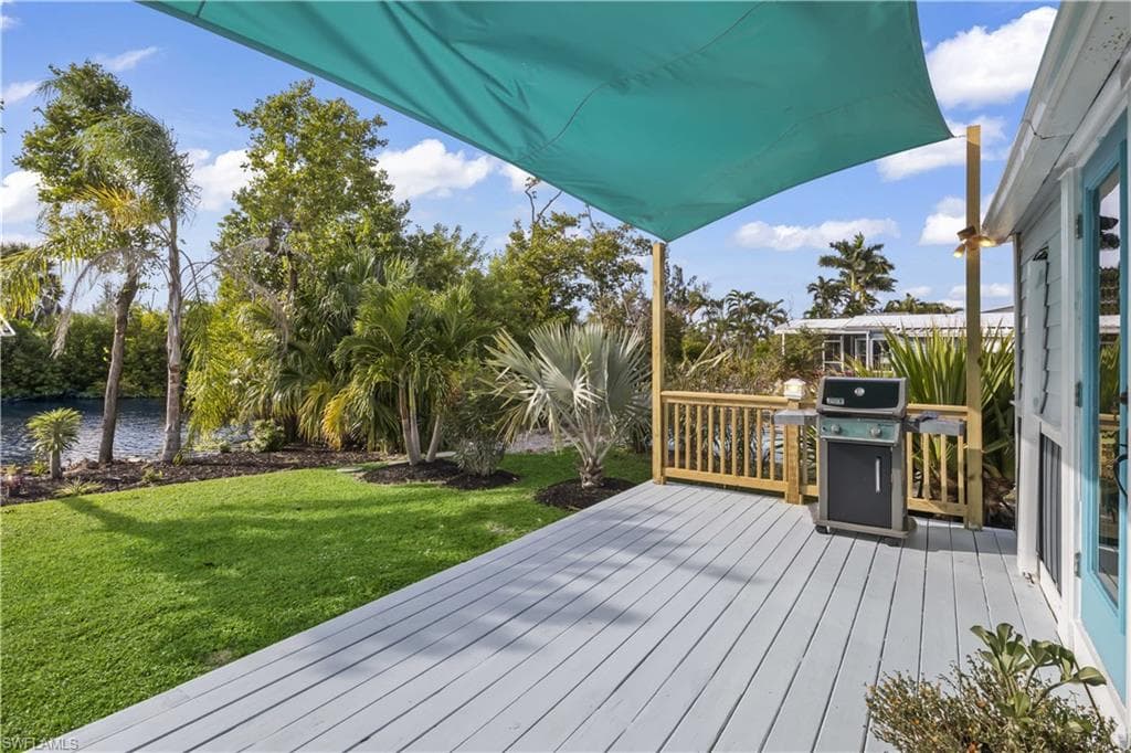 Outside to your PRIVATE WATERFRONT RETREAT featuring a composite deck with shade sail, perfect for outdoor dining, grilling, morning coffee, or sunset cocktails while enjoying gentle island breezes
