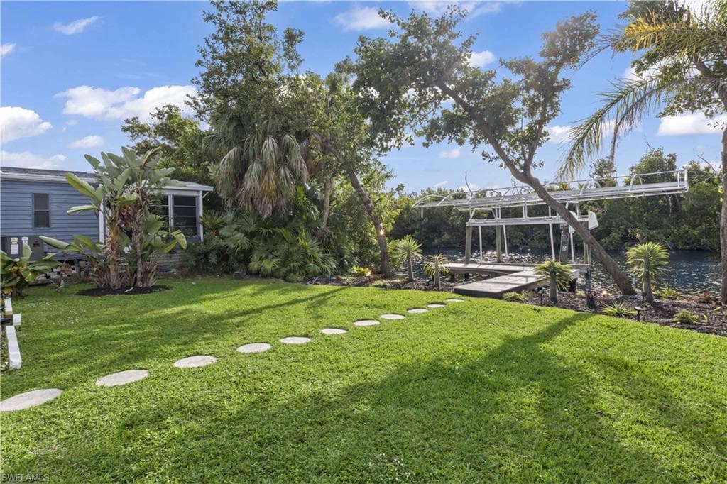 The beautifully maintained lawn extends directly to the water's edge, where your private dock and 10,000-lb boat lift await just steps from the home
