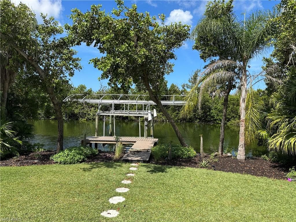 The beautifully maintained lawn extends directly to the water's edge, where your private dock and 10,000-lb boat lift await just steps from the home