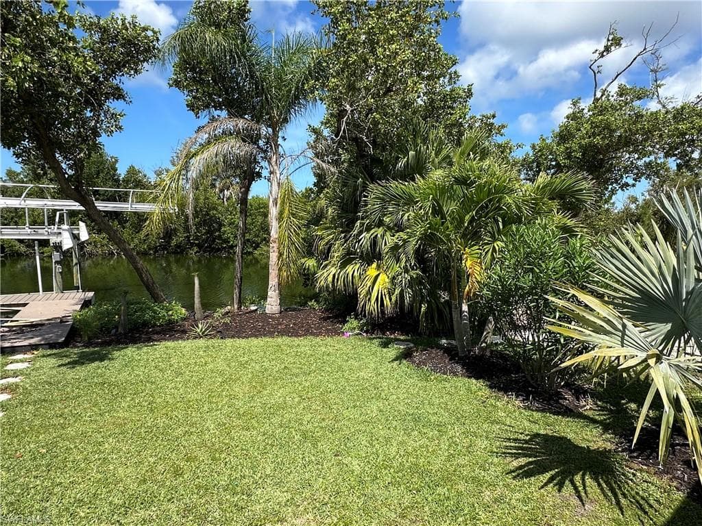 Mature palms, tropical landscaping, and lush greenery surround the property, creating exceptional wall privacy and a true backyard oasis