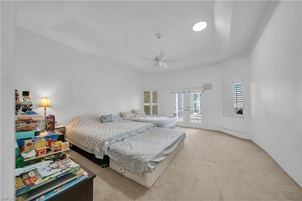 Large Master bedroom with ceiling fan and French doors out to the lanai
