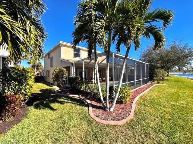 Rear view of house featuring a yard and a lanai