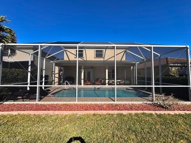 Rear view of property with a lanai, a lawn, ceiling fan, and a patio area