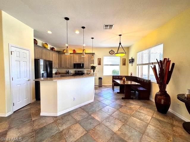 Kitchen featuring pendant lighting and black appliances