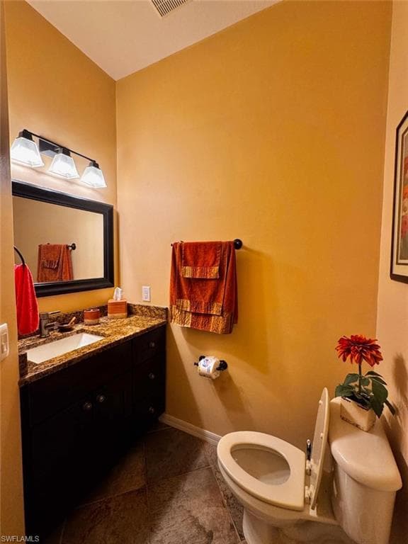 Bathroom featuring vanity, tile patterned floors, and toilet