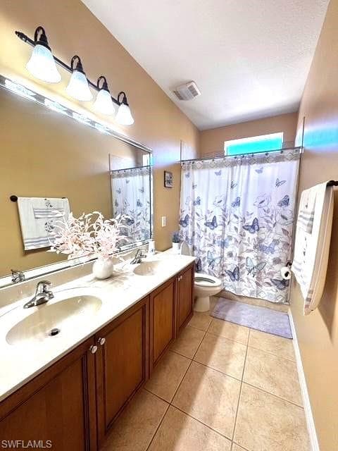 Bathroom with tile patterned floors, toilet, and vanity
