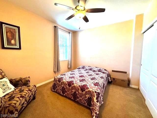 Bedroom featuring ceiling fan, a closet, and carpet
