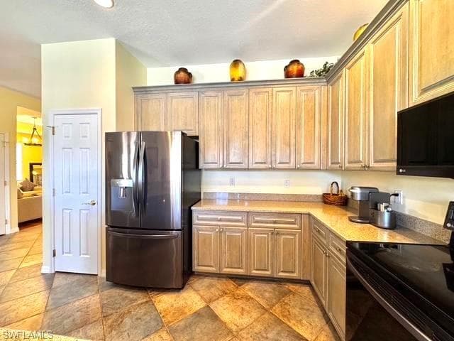 Kitchen featuring stainless steel refrigerator with ice dispenser and electric range