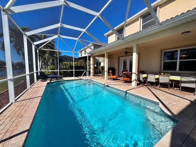 View of pool featuring french doors, glass enclosure, ceiling fan, and a patio area