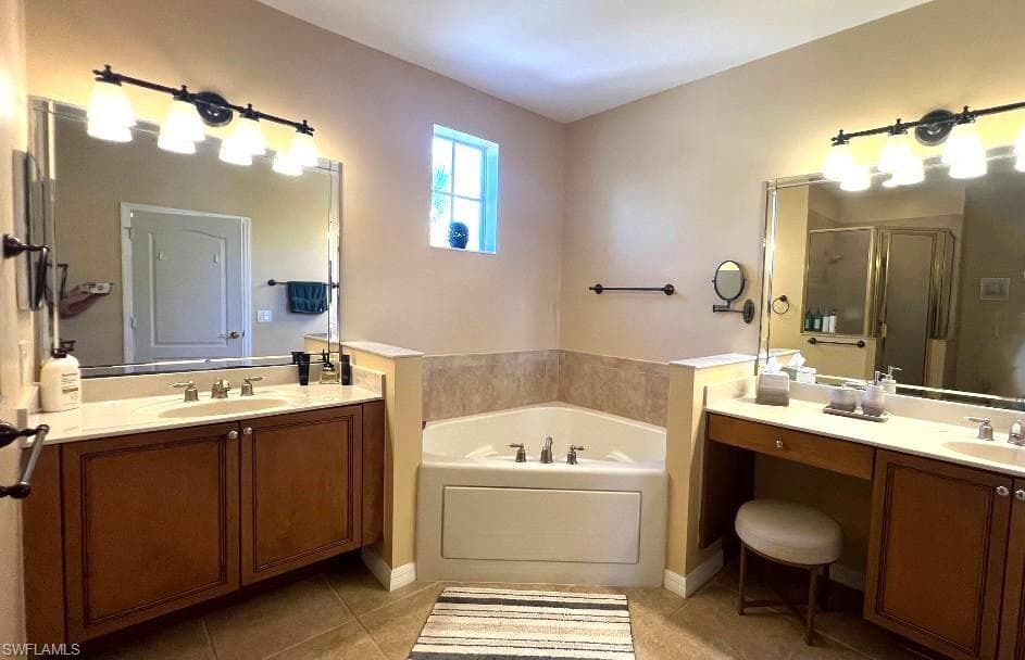 Bathroom with tile patterned floors, vanity, and plus walk in shower