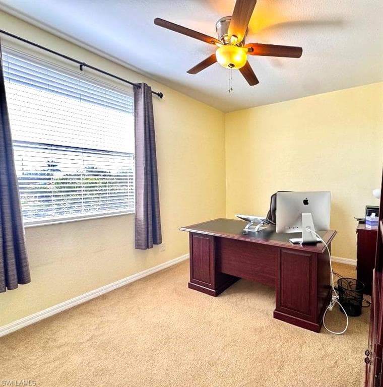 Office with ceiling fan and light carpet