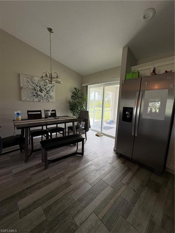Open concept dining area featuring wood-finish tile flooring and vaulted ceilings