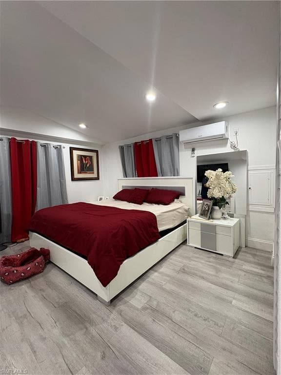 Spacious room featuring light wood-finish flooring, recessed lighting, and a wall-mounted air conditioning unit